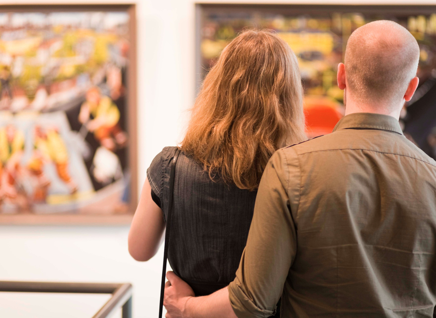 couple walking round a gallery or museum looking at paintings